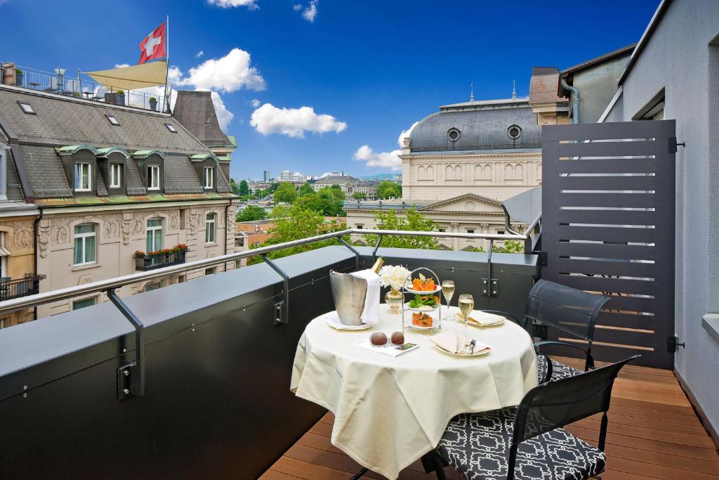 a table on a balcony with a view of a city at Opera Hotel Zürich in Zürich