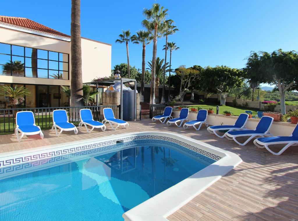 a swimming pool with lounge chairs next to a building at ViVaTenerife - Immense villa, unique and exclusive in Chayofa