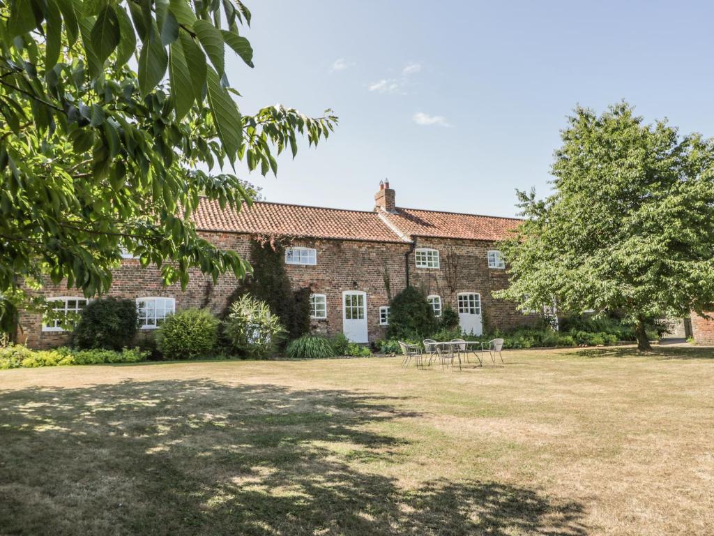 an old brick house with a large yard at Bramhill Barns in Burton Pidsea