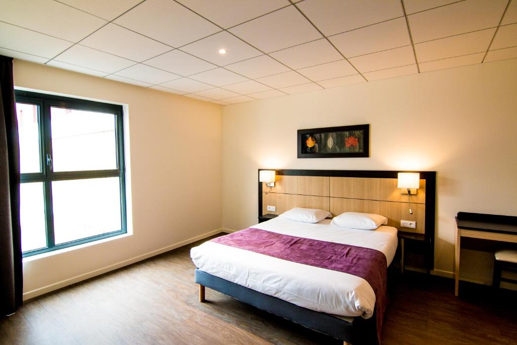 a bedroom with a large bed and a window at Tulip Inn Thionville Residences in Thionville