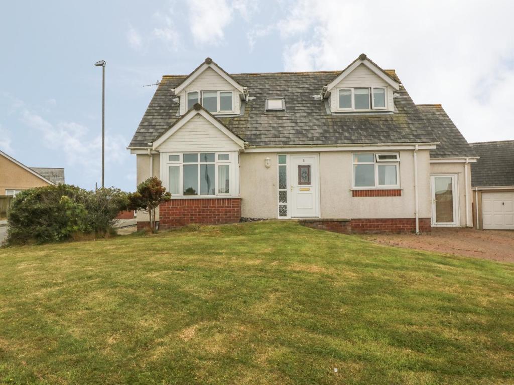 a house with a lawn in front of it at 5 Cae Derwydd in Cemaes Bay