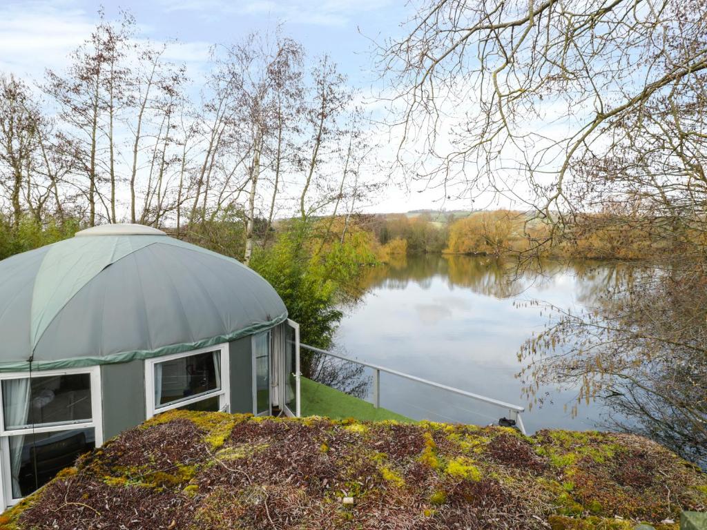 einen Pavillon neben einem Wasserkörper in der Unterkunft Lakeview Yurt in Beckford