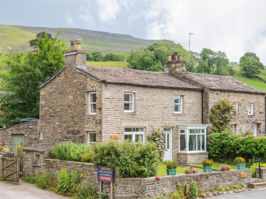 an old stone house on the side of a road at The Homestead in Hawes