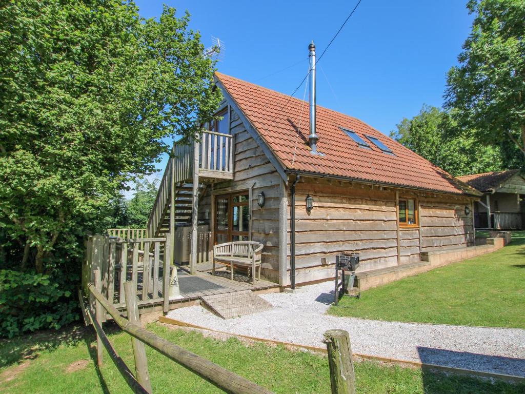 a wooden cabin with a fence in front of it at Hazel Lodge in Washford