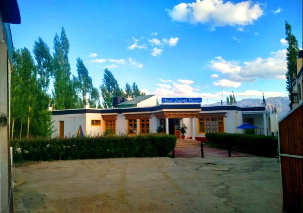 a white building with a blue sign on it at Hotel Ladakh Heaven in Leh