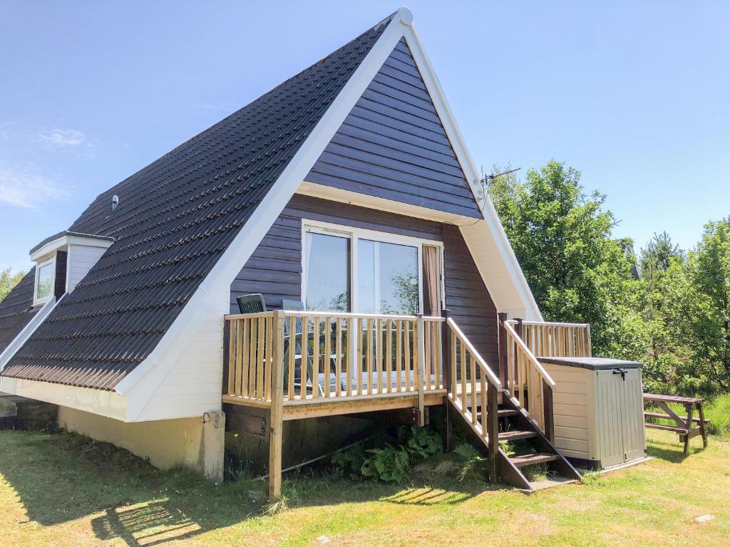 a small house with a gambrel roof with a deck at Suil Na Mara in Aultbea