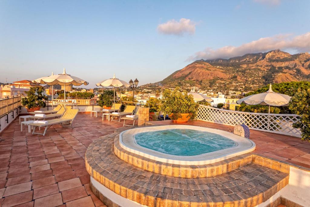 a hot tub on a patio with a view of the mountains at Hotel Nettuno in Ischia