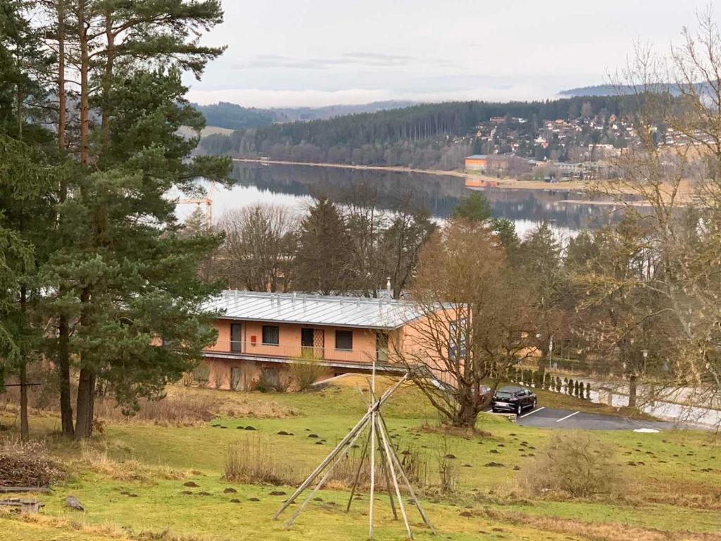 a house on a hill with a view of a lake at L&B Lake view modern apartment in Lipno nad Vltavou