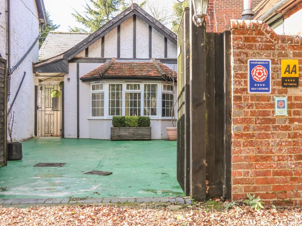 uma porta aberta para uma casa com um quintal em Woodend Annexe em Slindon