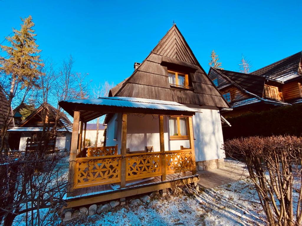 ein kleines Haus mit einem Dach im Schnee in der Unterkunft Domek Leśny in Zakopane
