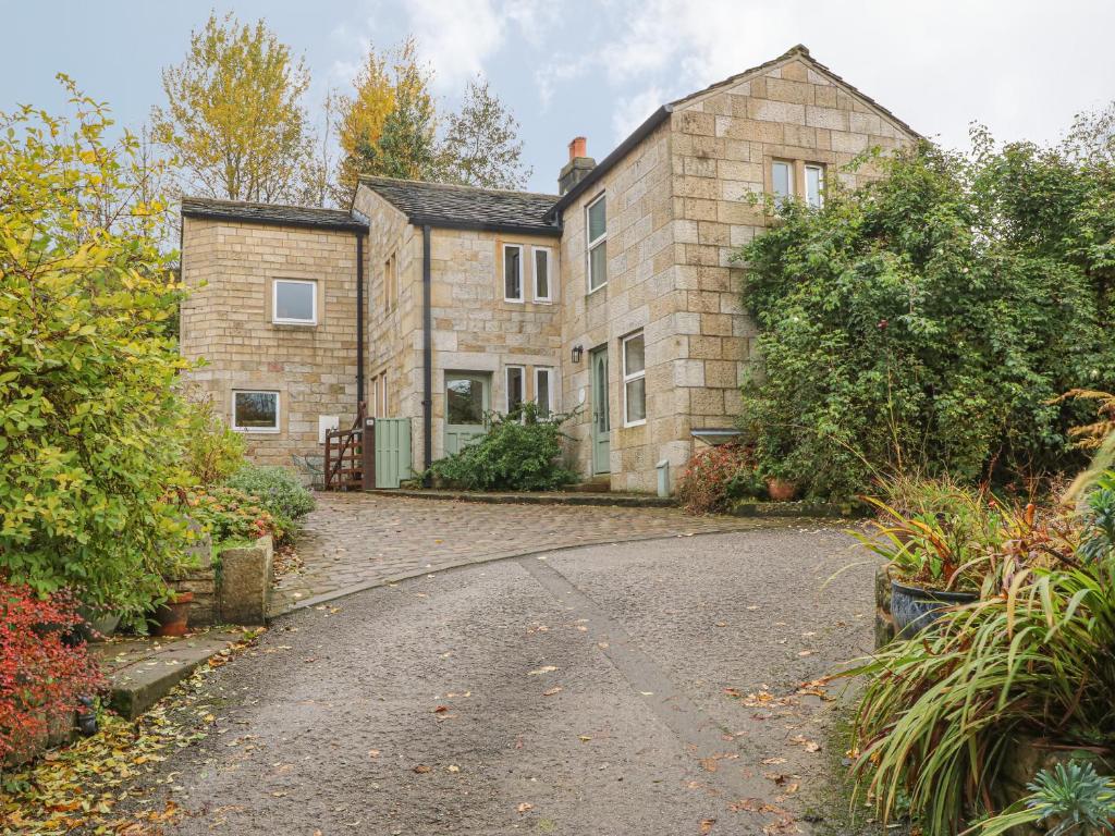 a stone house with a driveway in front of it at Salter Rake Gate Cottage in Walsden