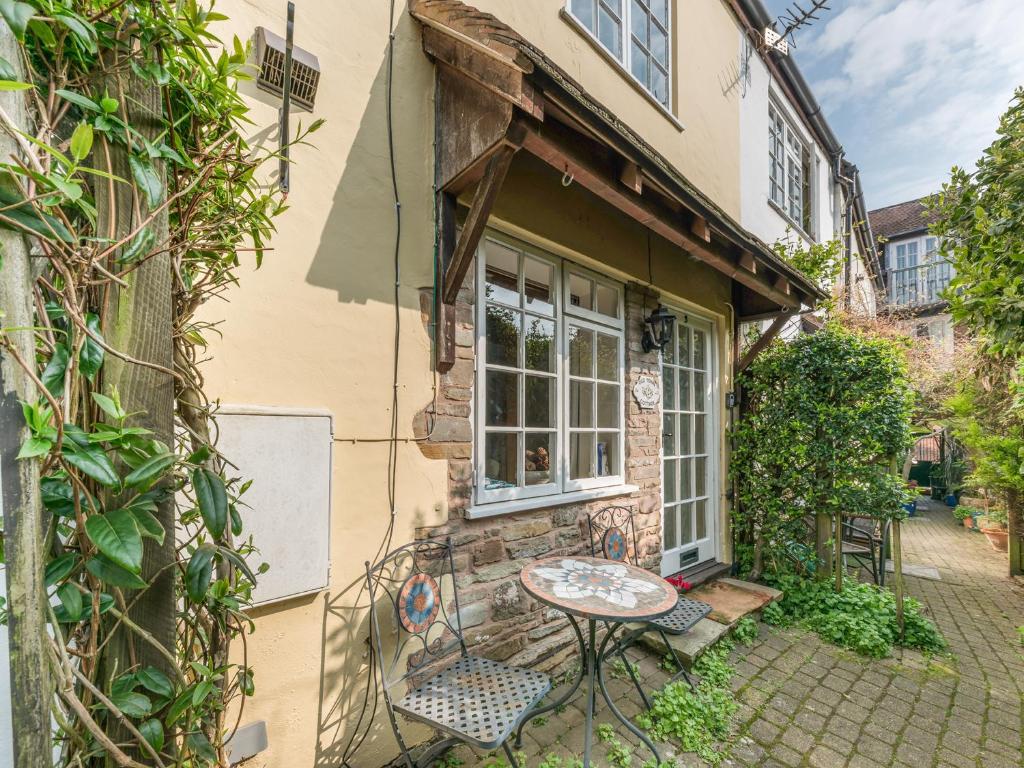 a patio with a table and chairs outside of a house at Old Town Cottage in Ludlow
