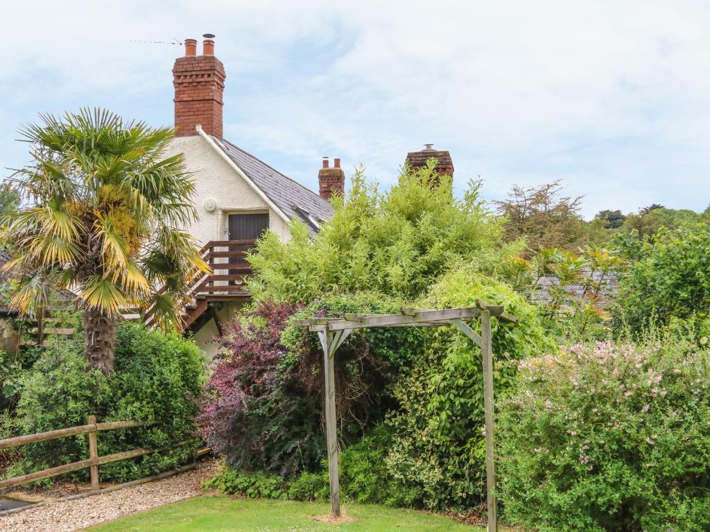 a garden with an arch in front of a house at Fig Trees - Wibble Farm in Williton