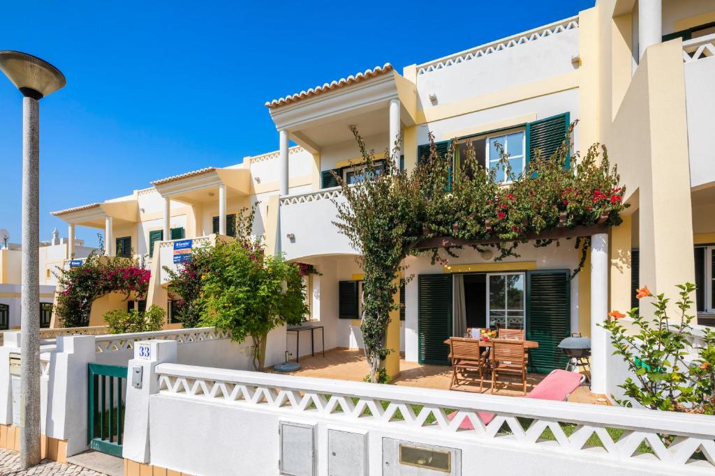une villa avec balcon et plantes dans une rue dans l'établissement Casa Madeleina (33), à Benagil