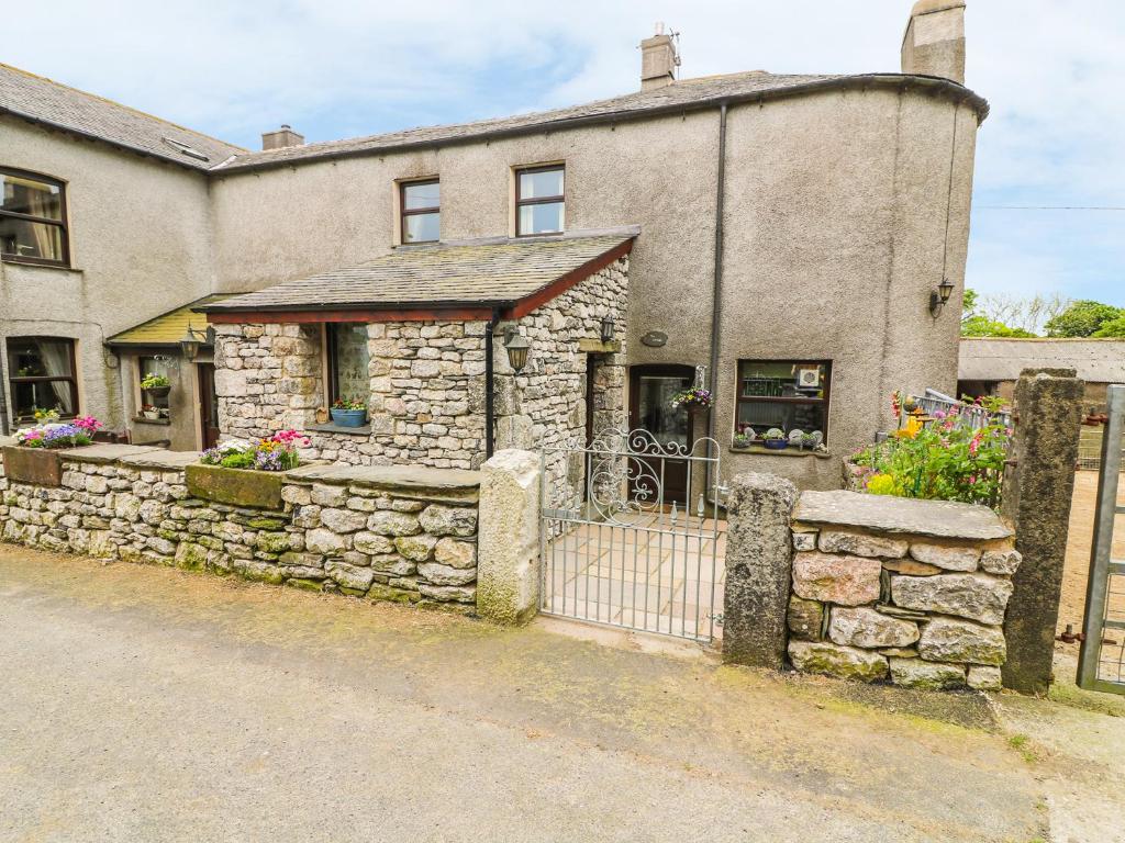 a stone house with a gate and a fence at Horrace Farm Cottage in Pennington