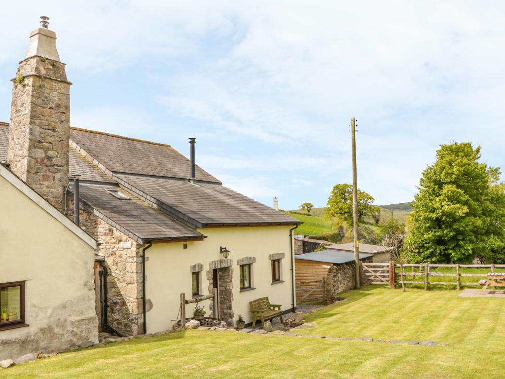 een oud stenen huisje met een grasveld bij Higher Whiddon Farm Whiddon Well in Ashburton