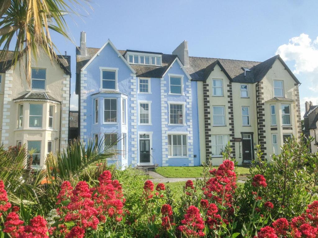 una fila de casas con flores en primer plano en Sea View Apartment en Llanfairfechan