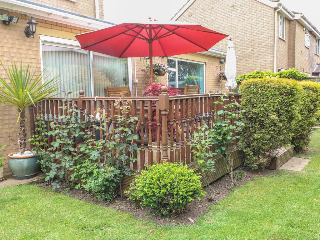 a wooden fence with an umbrella in a yard at Brayton Retreat in Brayton