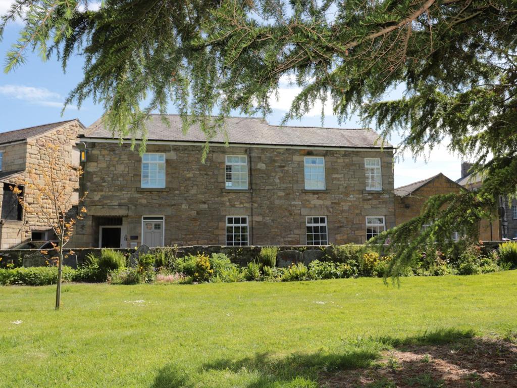 a large brick house with a green yard at St Lawrence Rest in Warkworth