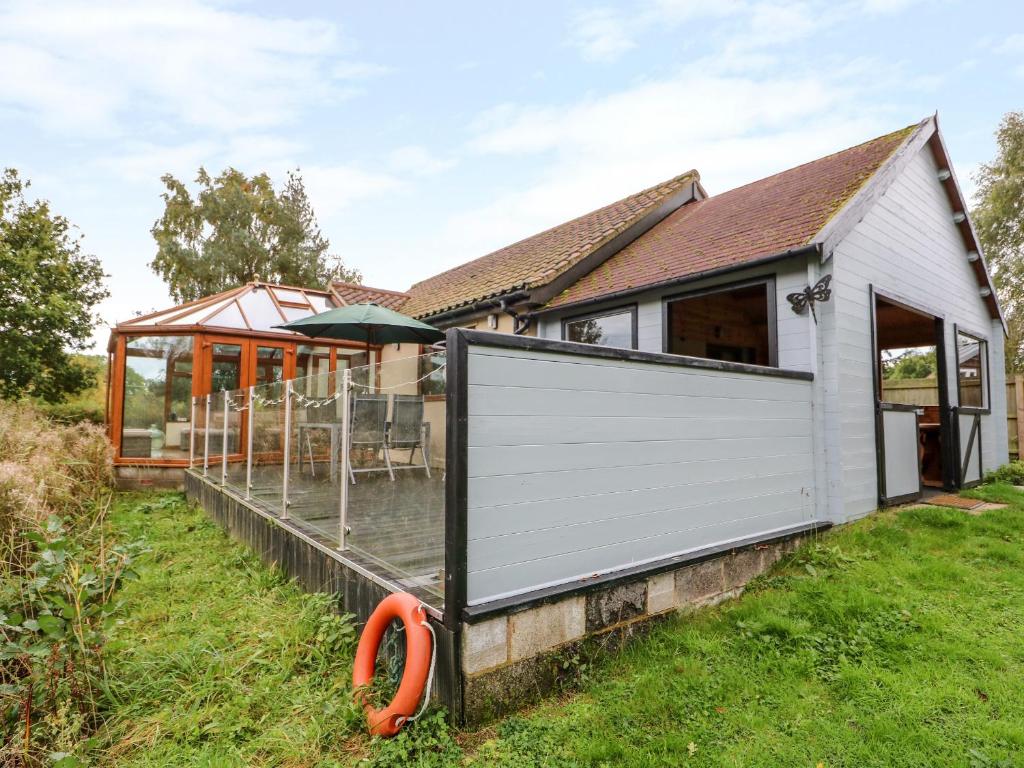 a house with a white garage door in the yard at Dragonfly Lodge in Yaxham