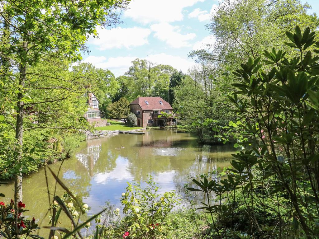 a view of a river with a building in the background at Miswells Cottages - Lake View in Turners Hill