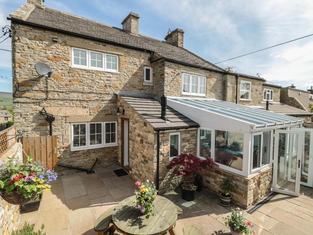 an extension to a stone house with a conservatory at Belgrave House in Mickleton