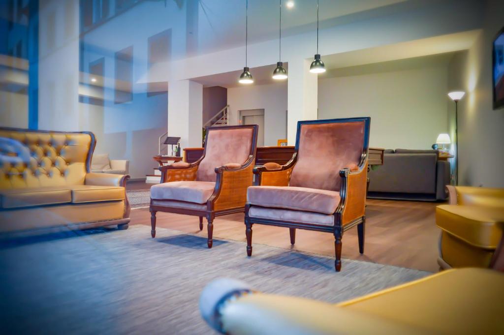 フンシャルにあるCBA Suites Madeiraの椅子3脚とソファ1脚付きの待合室