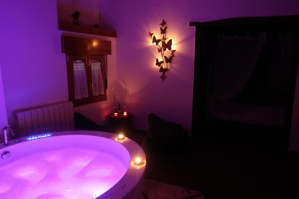 a purple bathroom with a tub with lights in it at La Morada del Druida in Los Narros