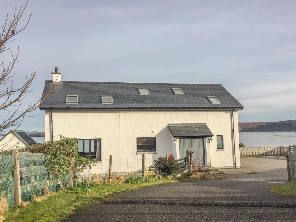 a white house with a black roof at Coast House in Little Gruinard