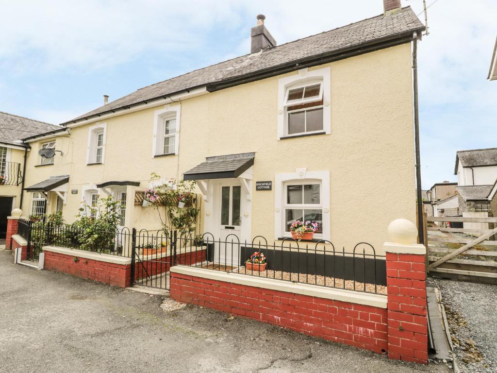 a house with a black fence in front of it at Brickfield Cottage in Machynlleth