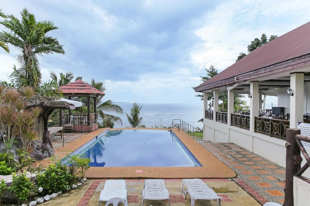 a house with a swimming pool next to the ocean at OYO 435 La Veranda Beach Resort in Panglao Island