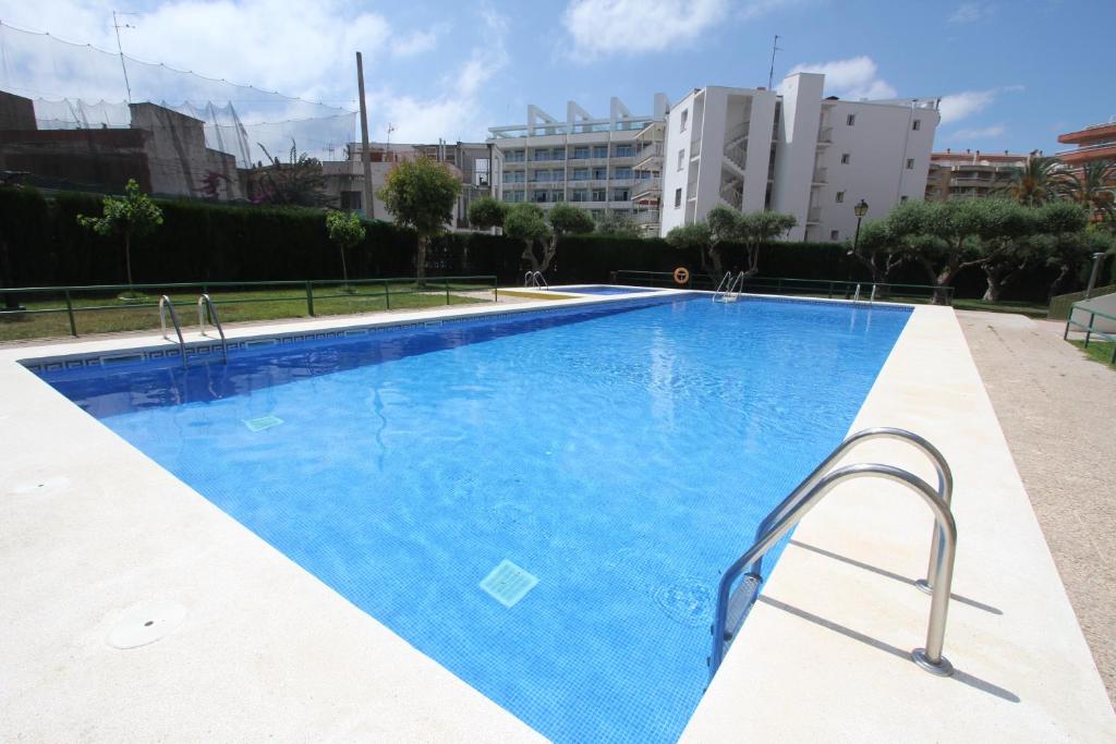 a large blue swimming pool with buildings in the background at For a Stay DMS III in Salou
