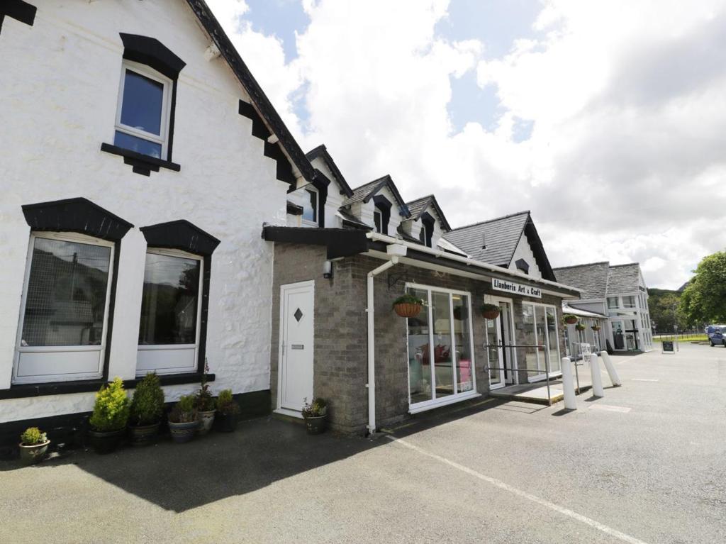 a white building with a lot of windows at Station Apartment in Llanberis