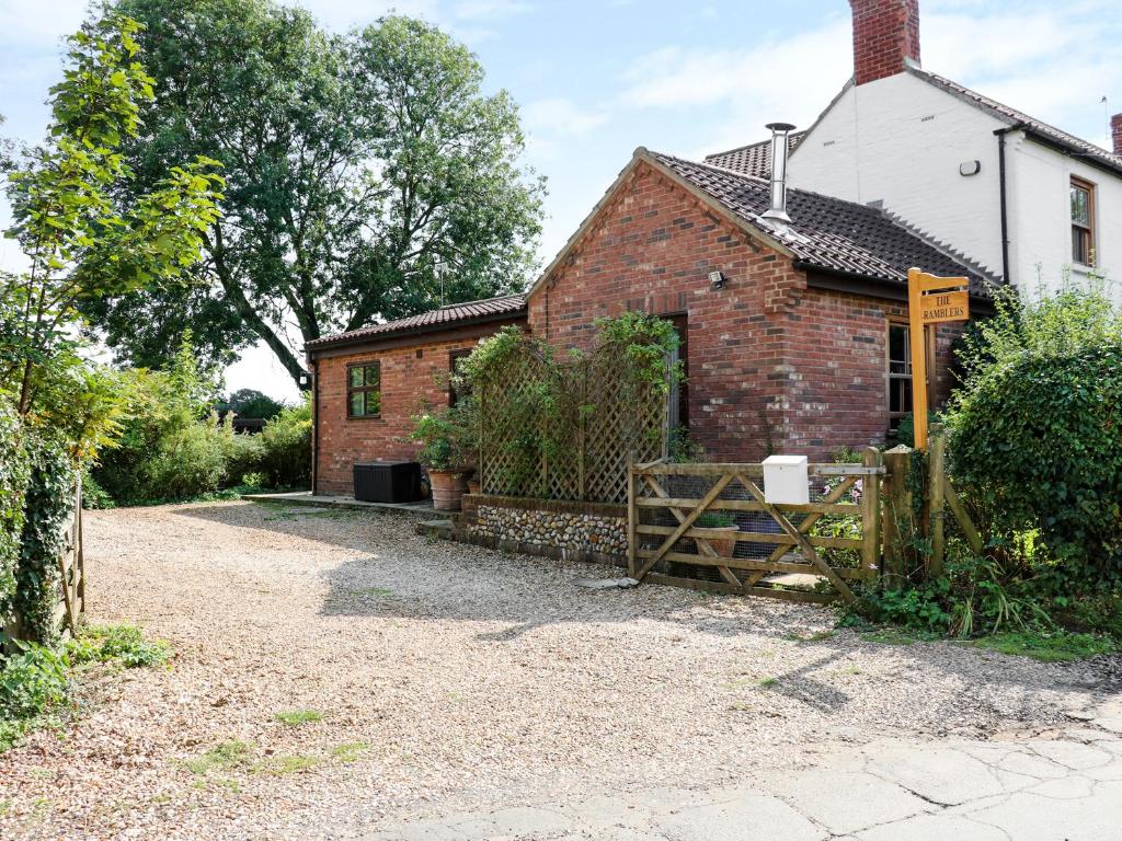 an old brick house with a gate in front of it at The Ramblers' Annex in North Tuddenham