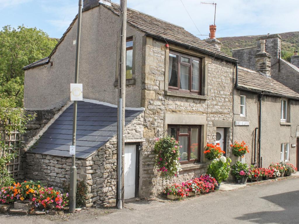 an old stone house with a blue roof at Lees Cottage in Bradwell