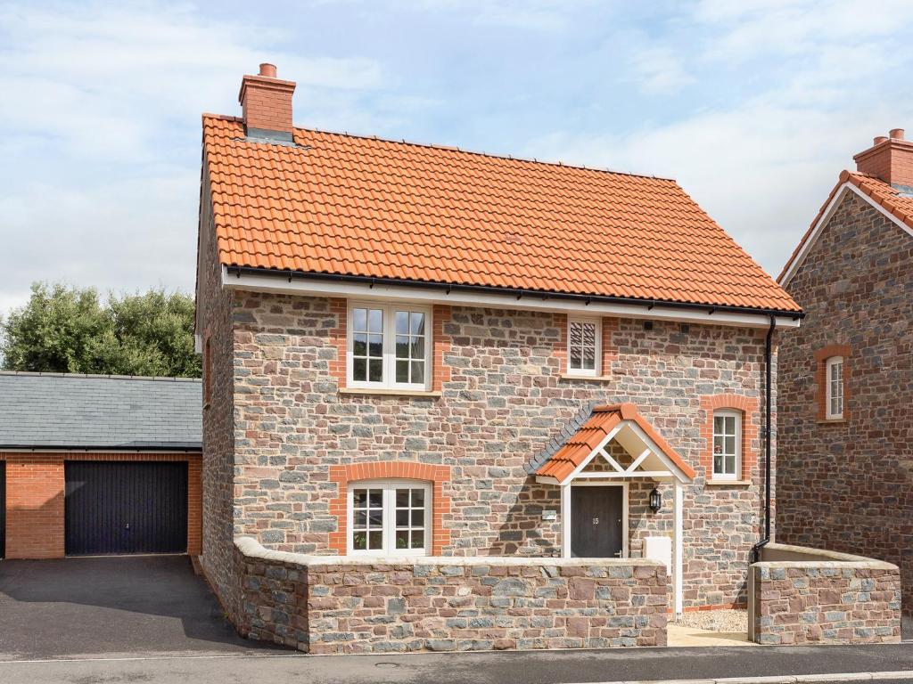 an old brick house with an orange roof at Tus Nua Cottage in Carhampton