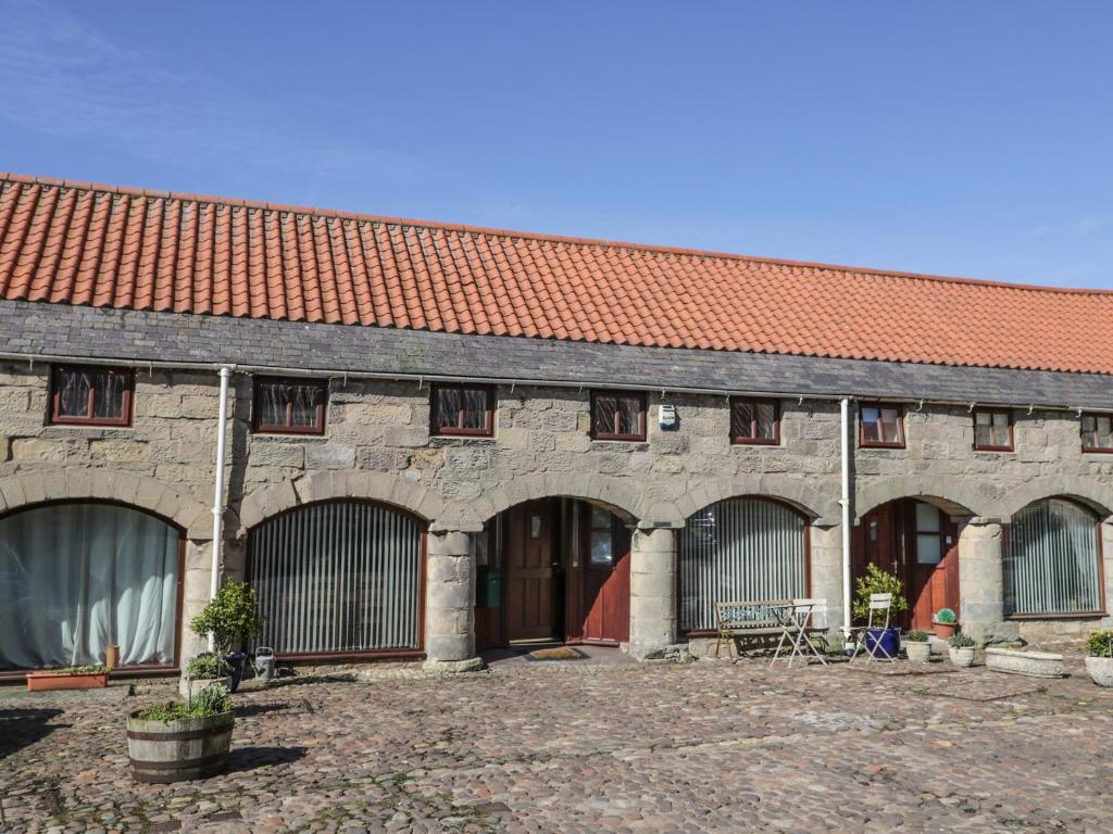 a large brick building with a red roof at The Mistal in Glanton