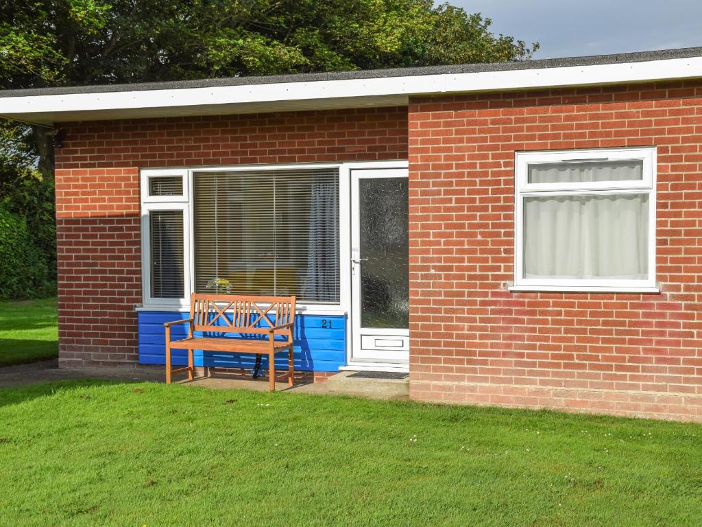 a brick house with a sign that says happy walkify at 21 Siesta Mar in Mundesley