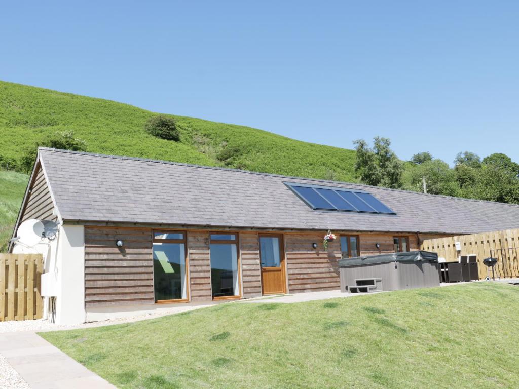 ein Haus mit Sonnenkollektoren auf dem Dach in der Unterkunft 1 Beacon View Barn in Felindre