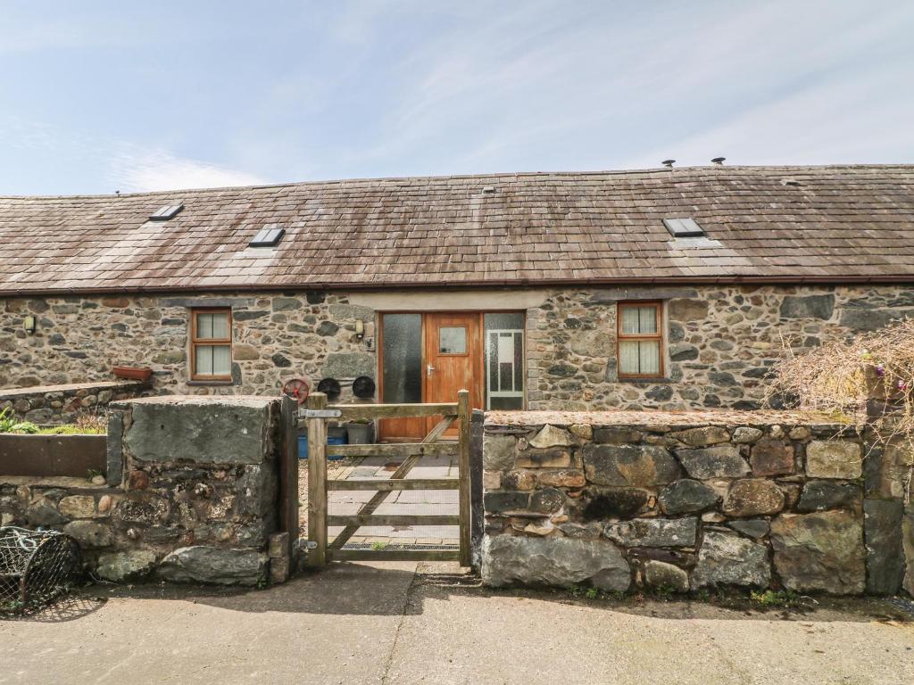 una antigua casa de piedra con puerta de madera en Beudy Mawr, en Llanddeiniolen