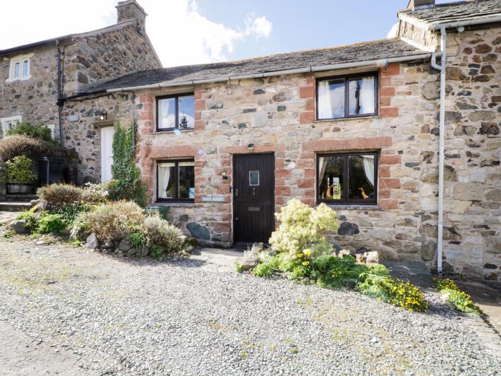 an old stone house with a driveway in front of it at Barn Roost in Uldale