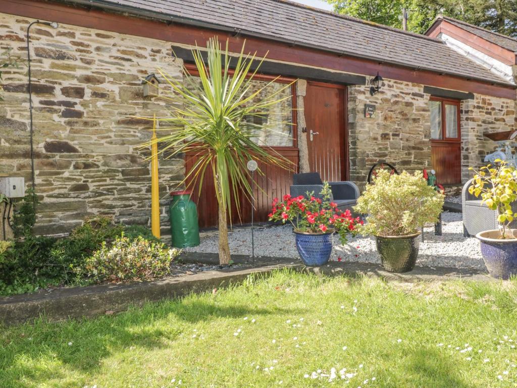 a stone cottage with plants in front of it at Barn Cottage in Liskeard