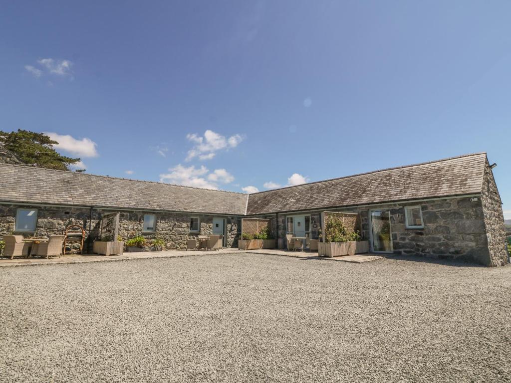 an old stone building with a gravel driveway at Cornel Glyd in Dyffryn