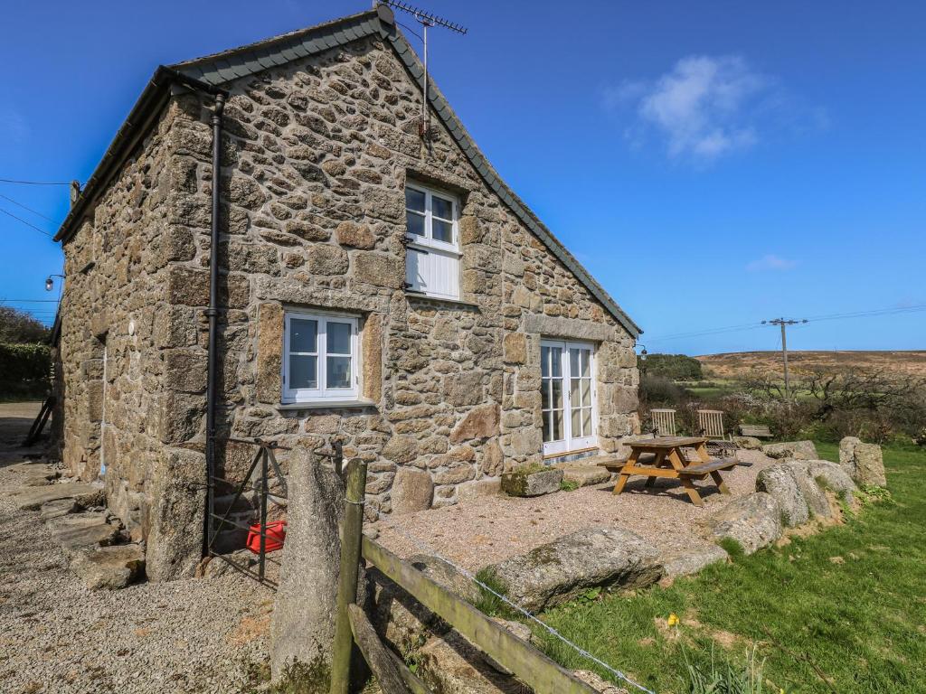 a stone house with a picnic table in front of it at Boar's House in Penzance