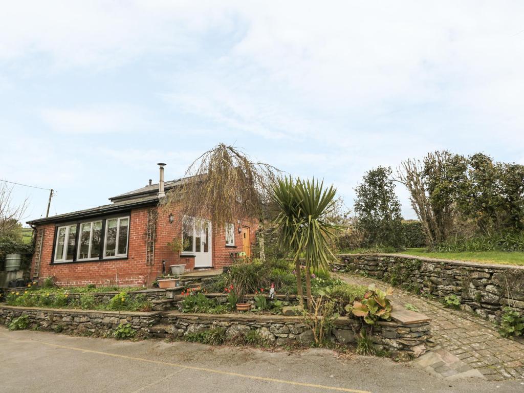 a brick house with a garden in front of it at Beck Cottage in Ulverston