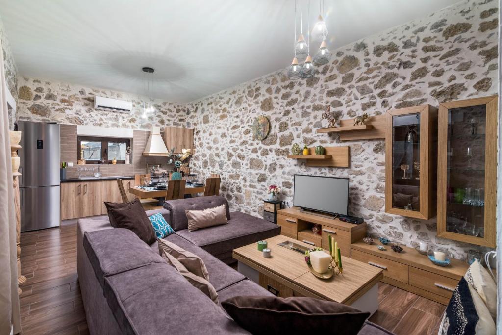 ein Wohnzimmer mit einem Sofa und einem TV in der Unterkunft Zaros Villa Fountarinis in Zarós