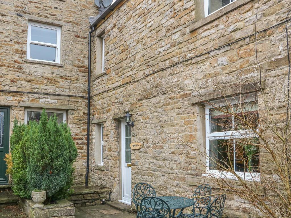 a brick building with a table and chairs in front of it at Bridge House in Hawes