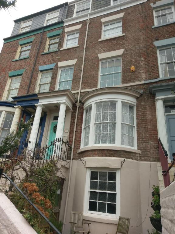 a large brick building with white columns and windows at Heavenly Outlook in Scarborough
