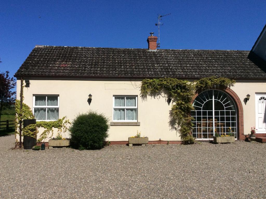 a white house with a window and a roof at Rose Villa in Llanymynech