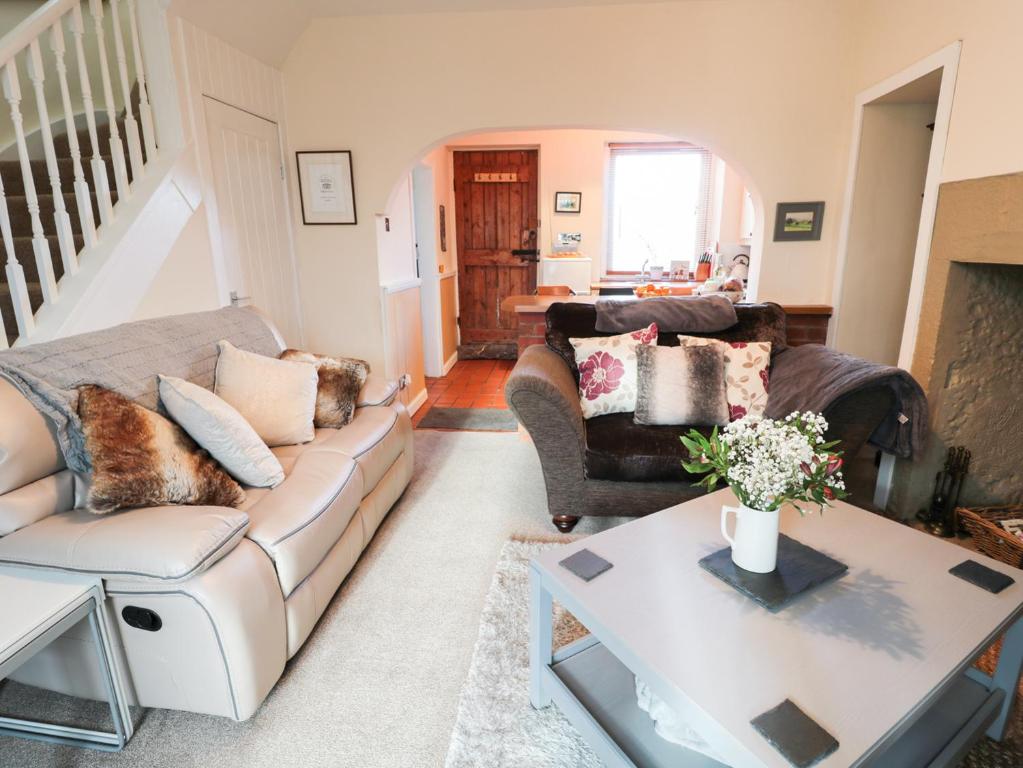 sala de estar con sofá y mesa en Corbett Cottage, en Cheswick